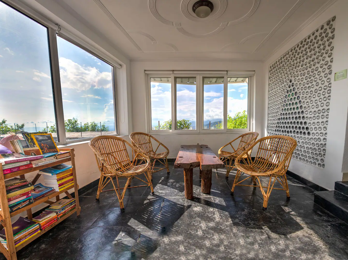 Sunroom with mountain views and glass bottle wall at Earthship Homestay
