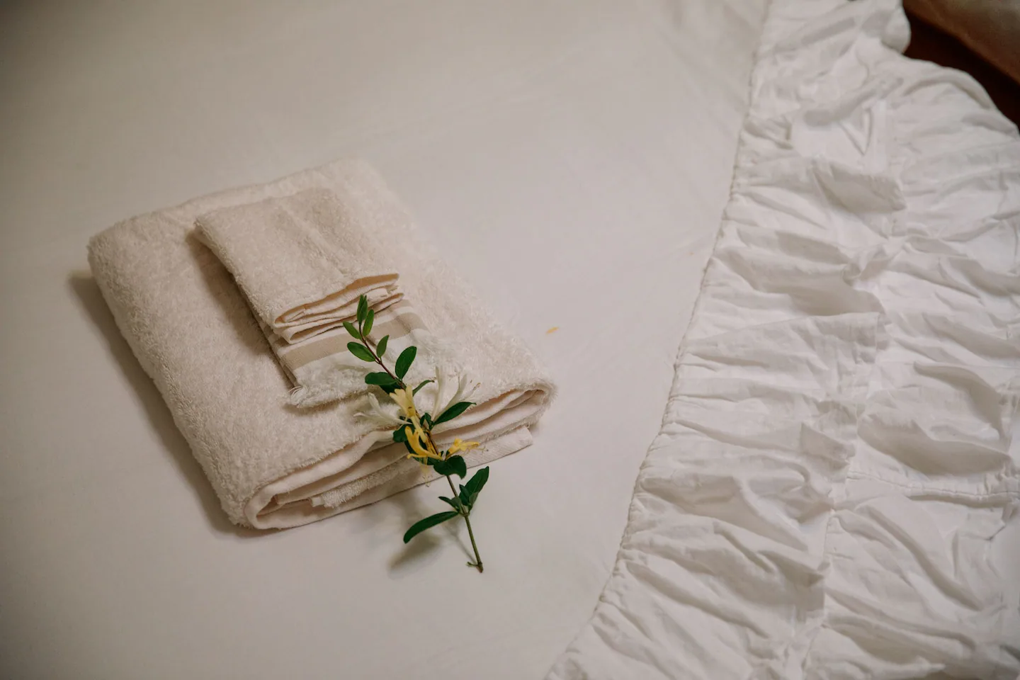 Welcome towels with fresh flower on the bed
